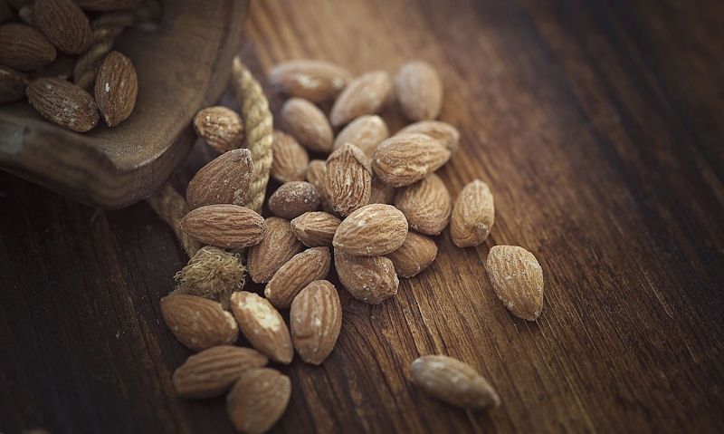 Spilled almonds on wooden board