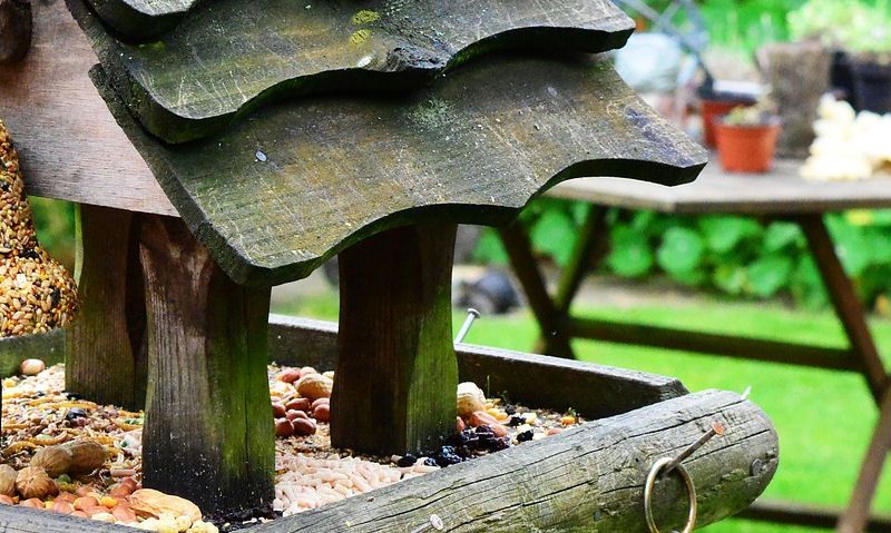 Heavy weathered bird table packed with bird seed, nut mixes