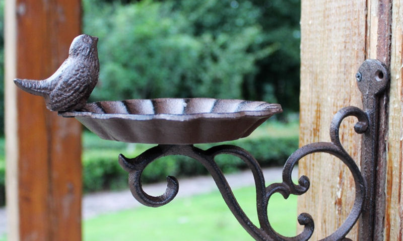 Cast iron bird bath mounted to wooden post